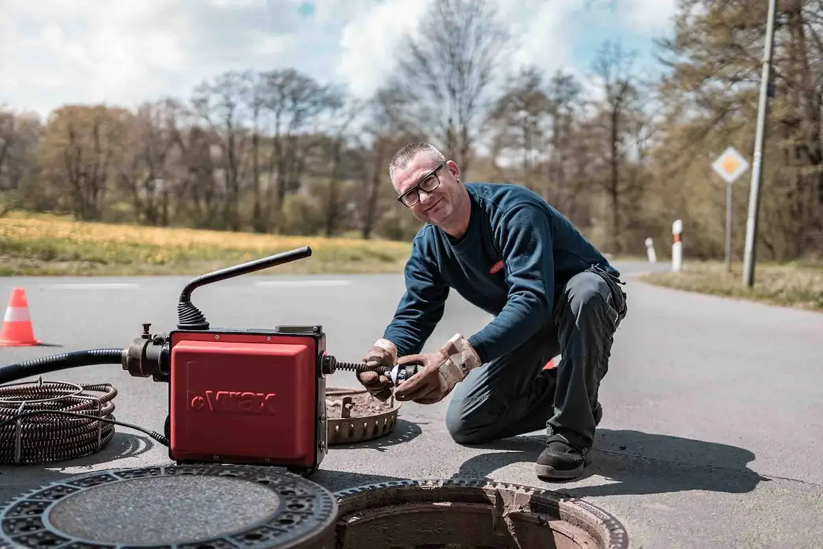 Experte bei der Kanalreinigung Adelberg arbeitet an Abwasserschacht.