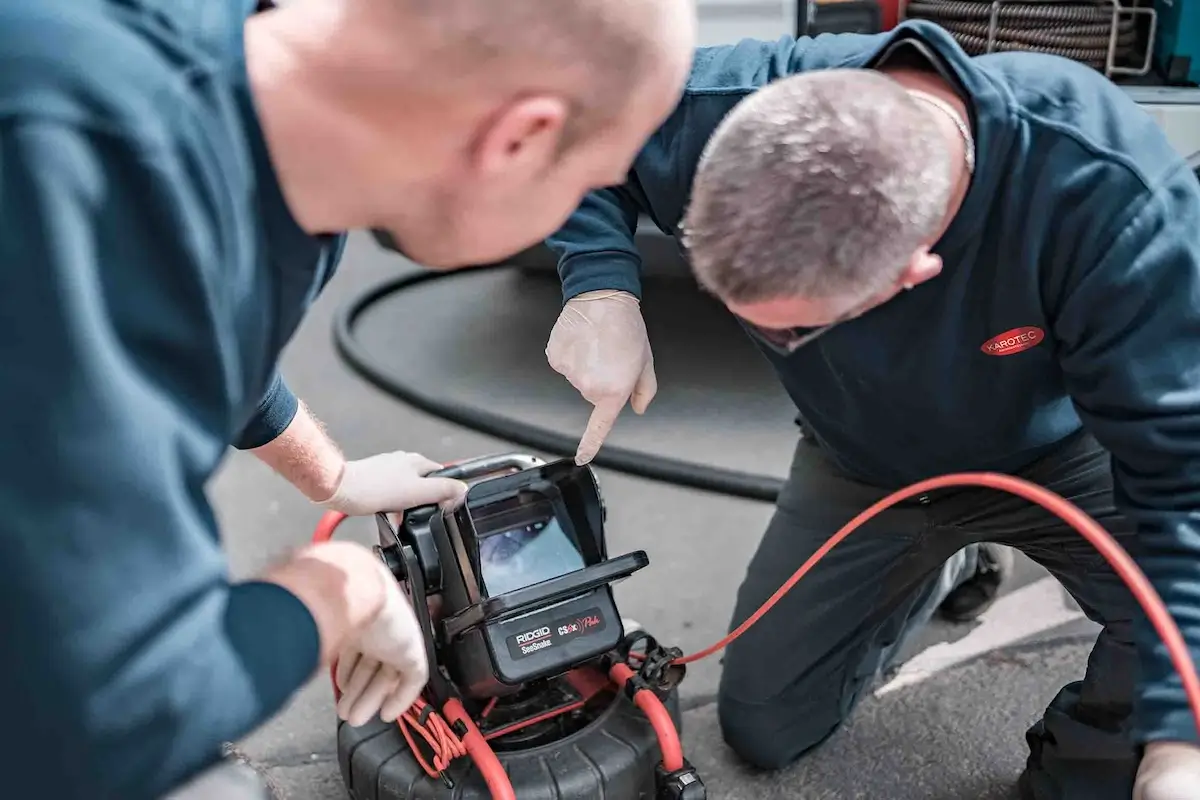 Techniker bei der Kanalreinigung Grafenau untersuchen ein Abflussrohr mittels Kamera.